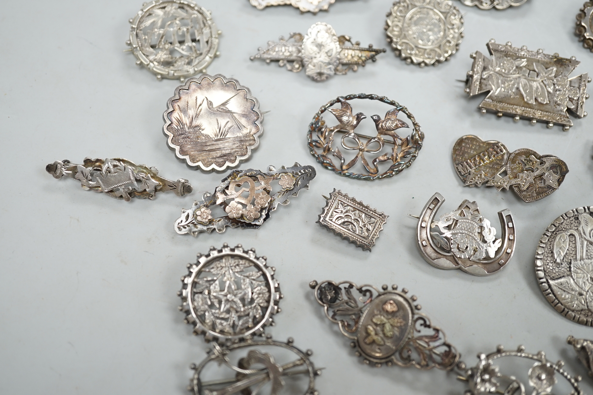 A small collection of twenty nine assorted Victorian and later silver or white metal brooches.